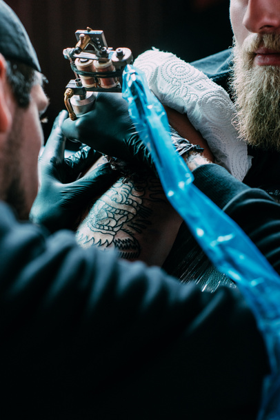 levágott lövés a tetoválás folyamatot a tetoválás a vállán a szalonban - Fotó, kép
