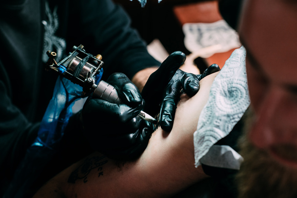 обрізаний знімок татуювання процесу татуювання на плечі в салоні
 - Фото, зображення
