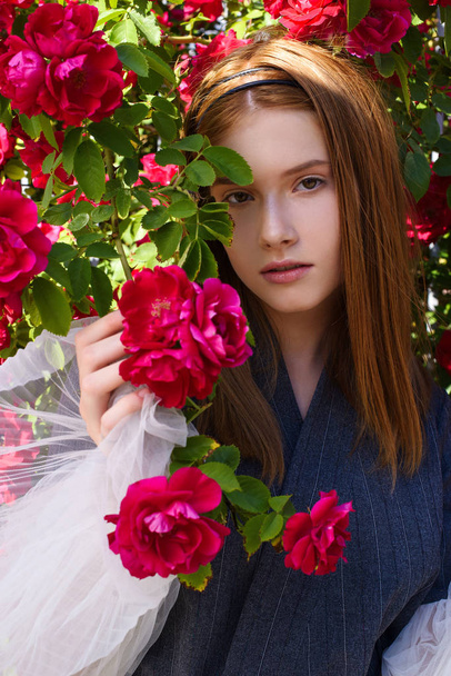 portrait of young redhead woman posing in flowers - Zdjęcie, obraz