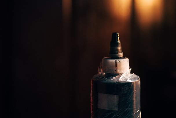 close up view of bottle with tattoo paint with blurred background - Photo, Image