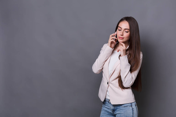 Pensive young businesswoman talking on phone - Foto, immagini