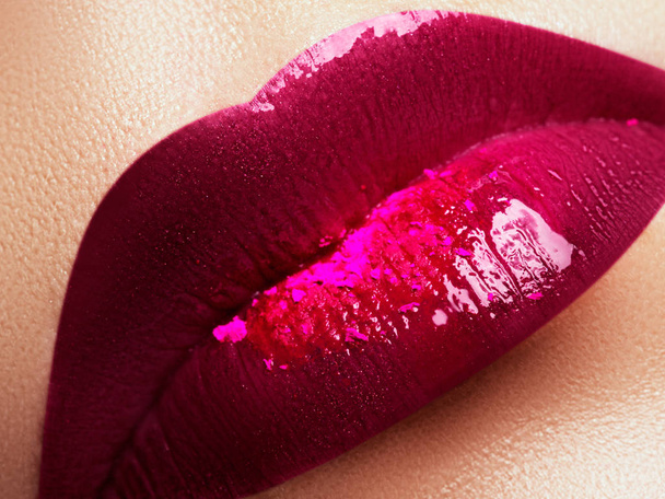Close-up van de mooie volle vrouw lippen met heldere fashion glans roze make-up. Macro geschoten met magenta lip make-up. Mooie rode lippen met roze pigment. Beauty en fashion concept - Foto, afbeelding