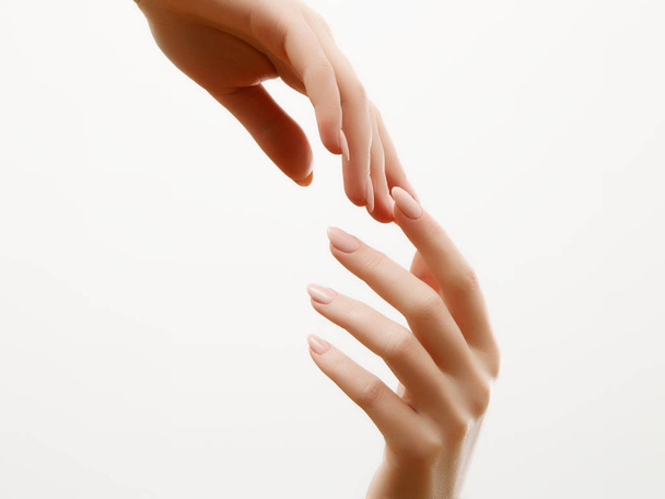 Cuidado de la piel de las manos. Primer plano de hermosas manos de mujer con manicura ligera en las uñas. Crema para manos y tratamiento
. - Foto, Imagen