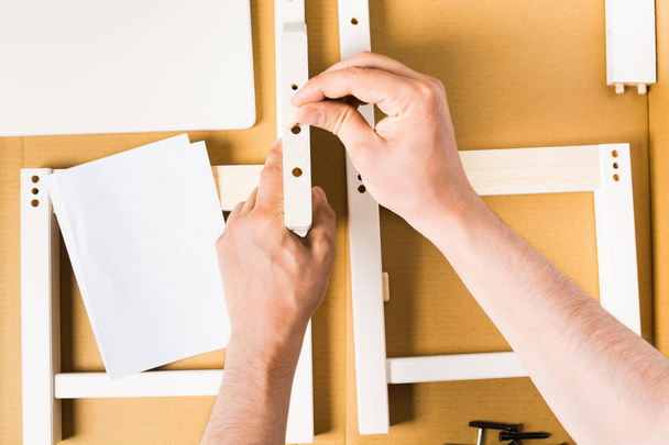Man hands assembling furniture from box, flat lay - Zdjęcie, obraz