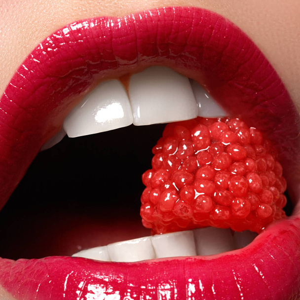 Kadının dudakları parlak moda kırmızı parlak makyaj ile Close-up. Makro kanlı lipgloss makyaj. Kırmızı seksi dudaklar. Açık ağız. Manikür ve makyaj. Güzellik ürünleri kavramı. - Fotoğraf, Görsel