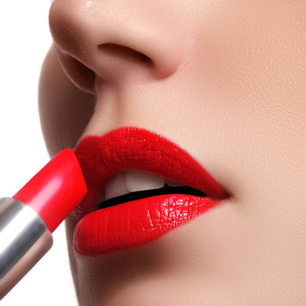 Femme appliquant du rouge à lèvres. Modèle lèvres rouges peintes. Visage beauté avec une peau fraîche parfaite. Concept de beauté
 - Photo, image