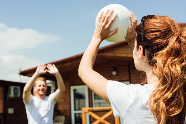 young couple playing volleyball on cottage yard - Photo, Image