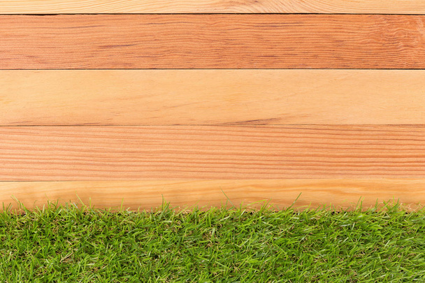 Syntetyczna trawa zielony i drewniane ściany, naturalne tło. - Zdjęcie, obraz