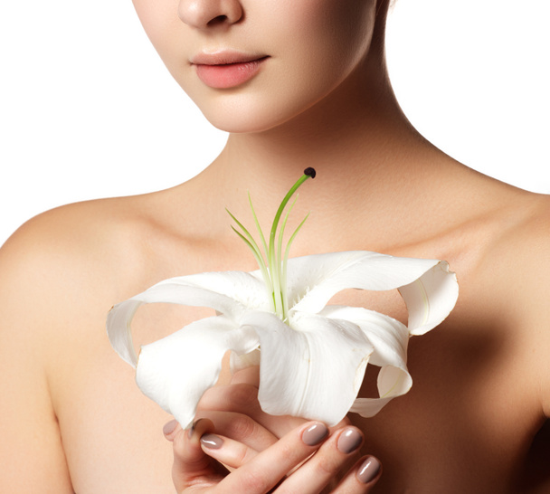 Pretty face of beautiful young woman with lily on hands - white background. Beauty face of young woman with flower. Beauty treatment concept - Photo, Image