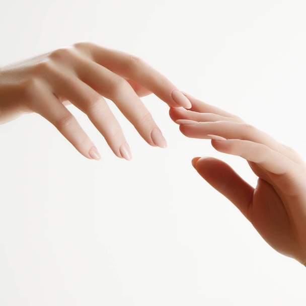 Kézi bőrápolás. Vértes könnyű manikűr köröm gyönyörű nő kezet. A kéz és a kezelés krém. - Fotó, kép