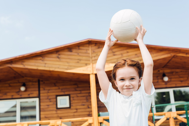rozkošné malé dítě s volejbalový míč při pohledu na fotoaparát - Fotografie, Obrázek