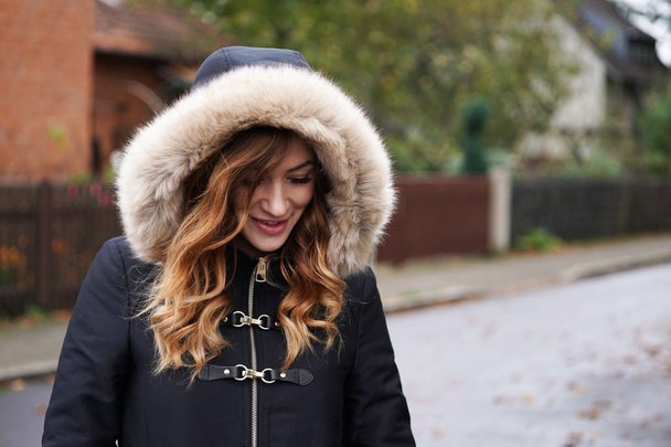 молода жінка в зимовому пальто з капюшоном грає колі
 - Фото, зображення