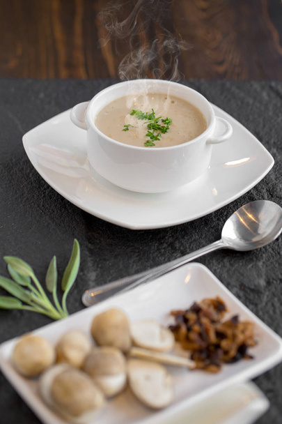 Mushroom cream soup with herbs and spices in white bowl. - 写真・画像