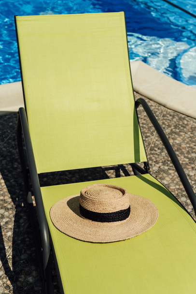 straw hat lying on sun lounger at poolside - 写真・画像