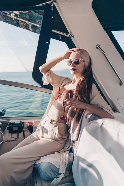 menina sexy elegante goza de uma rica vida e viagem marítima, bebe champanhe e poses
 - Foto, Imagem