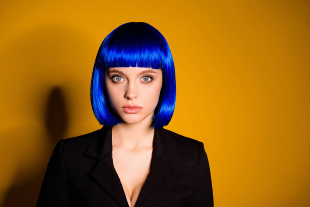 Portrait of strict gorgeous lady in black classic jacket blue wig  with bob haircut isolated on yellow background looking at camera. Theme party dress-code holiday concept - Foto, Imagem