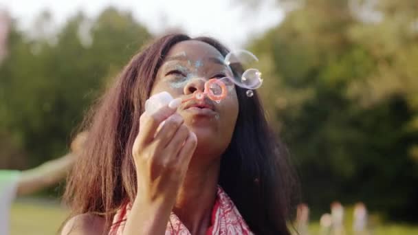 Mujer negra soplando burbujas de jabón en la fiesta de verano
 - Metraje, vídeo
