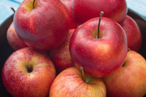 Manzanas rojas maduras frescas sobre mesa de madera azul
 - Foto, Imagen