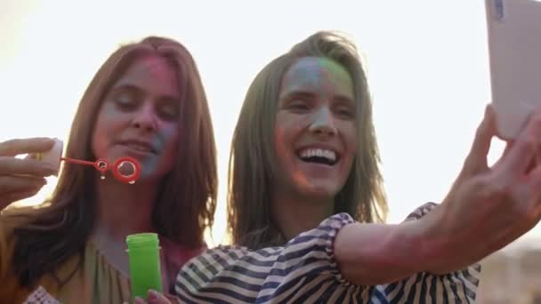 Värikkäitä ystäviä tekemässä selfie musiikkifestivaaleilla
 - Materiaali, video