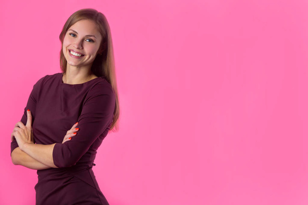 beautiful young girl with a smile on her face with flowing hair on a pink background - Fotoğraf, Görsel
