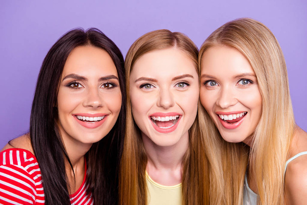 Head shot portrait of cheerful positive trio with beaming white smiles isolated on bright violet background - Foto, Imagem