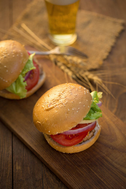 Cheese burgerów z grillowanego mięsa, sery, pomidory na powierzchni drewnianych - Zdjęcie, obraz