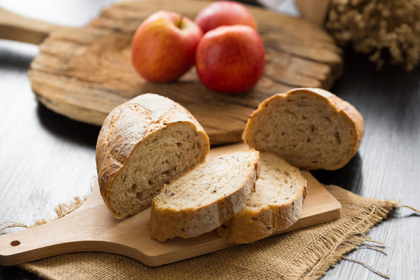 baguette de pan francés cortado sobre tabla de madera
 - Foto, Imagen