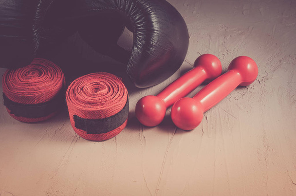 black boxing gloves and red dumbbells and bandage/sport and boxing concept with black boxing gloves and red dumbbells and bandage - Foto, afbeelding