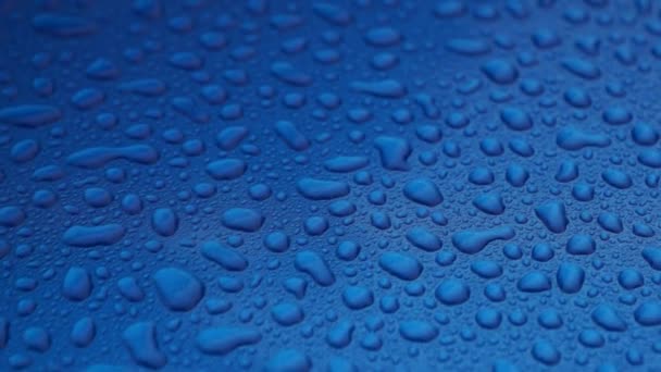 Krople deszczu na niebieski gładkiej powierzchni - Materiał filmowy, wideo