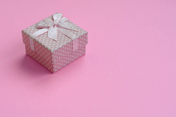 Small pink gift box lie on texture background of fashion pastel pink color paper in minimal concept. - Photo, Image