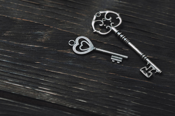 Два старовинні бронзові ключі на дерев'яному столі. Крупним планом перегляд
 - Фото, зображення