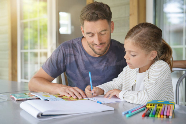 Papa mit kleinem Mädchen bei den Hausaufgaben - Foto, Bild