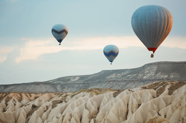 Three hot air balloons flying over the rocks of Cappadocia, Turkey - Photo, Image