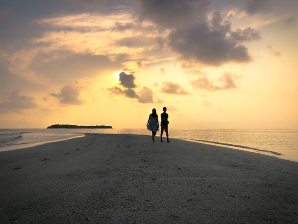 Obraz z dwóch ludzi w miłości o zachodzie słońca na Fehendhoo island, Malediwy - Zdjęcie, obraz