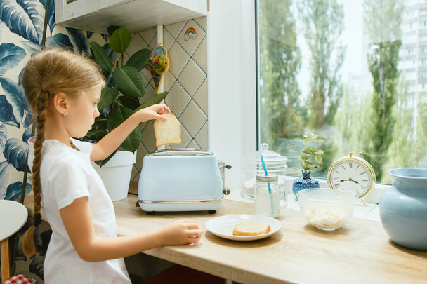 Beautiful girl in her kitchen in the morning preparing breakfast at home - Fotografie, Obrázek