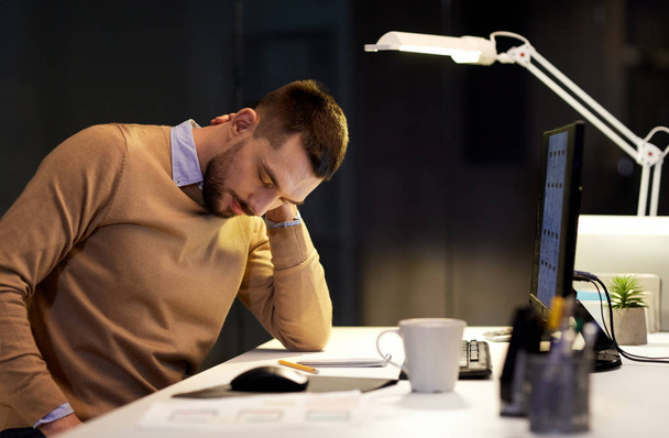 hombre cansado teniendo dolor de cuello trabajando en la oficina nocturna
 - Foto, Imagen