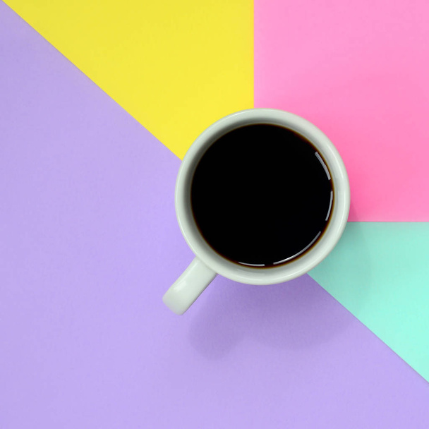 Pequena xícara de café branco no fundo textura da moda pastel azul, amarelo, violeta e rosa cores papel no conceito mínimo
. - Foto, Imagem