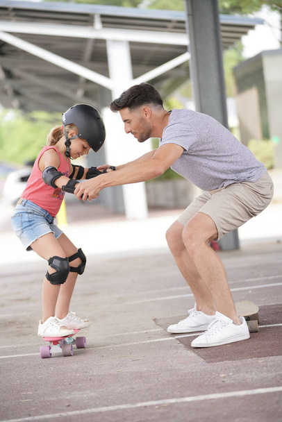 Young girl with dad learning how to skate - Foto, Bild