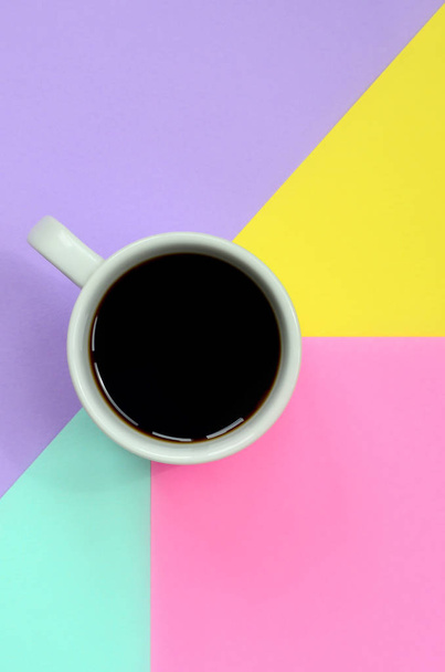 Piccola tazza di caffè bianco su sfondo texture di moda pastello blu, giallo, viola e rosa colori carta in concetto minimale
. - Foto, immagini