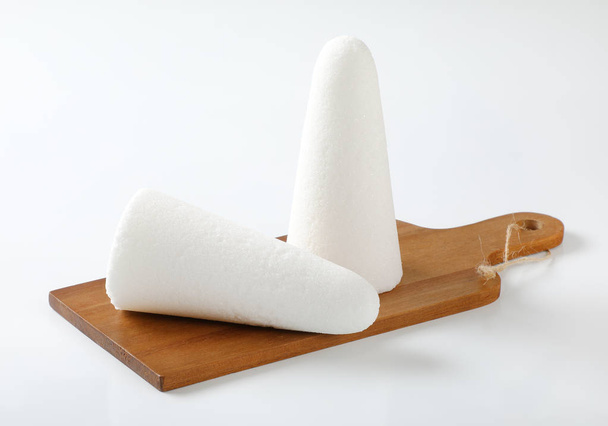 два белых сахарных хлеба или шишки на деревянной доске
 - Фото, изображение
