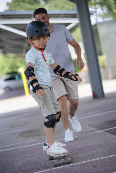 Young boy with dad learning how to skate - Foto, Bild