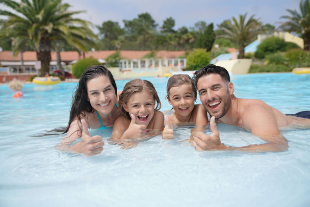 Cheerful family in hotel swimming-pool - Foto, imagen