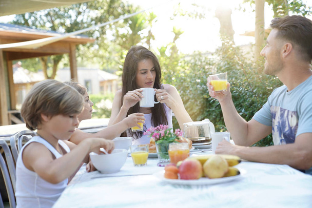 Family having breakfast in summer morning - 写真・画像