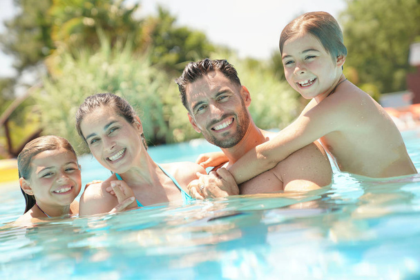 Portrait of happy family at the swimming-pool in summer  - Foto, Bild