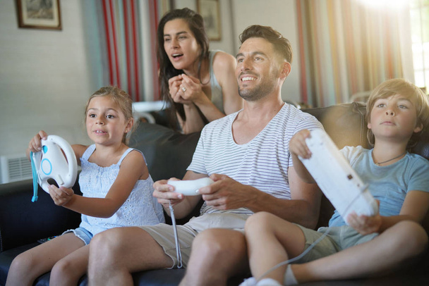 Family having fun at home playing video game - Фото, изображение