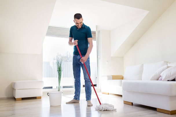 man with mop and bucket cleaning floor at home - Foto, Bild