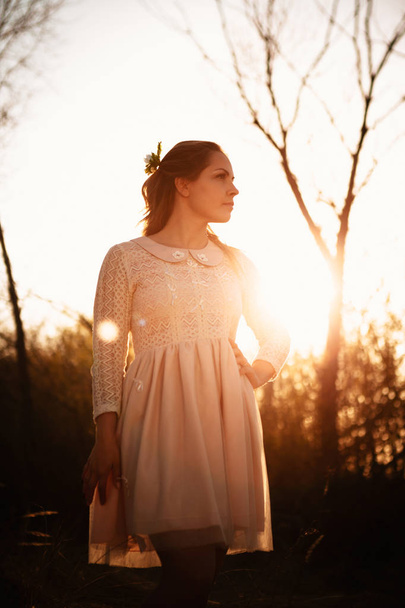 portrait of a girl in a field on a sunset background. - Zdjęcie, obraz