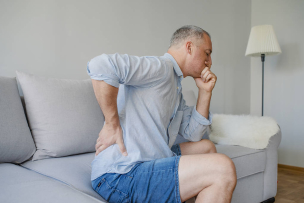 Back Pain. Closeup Of mature man Having Spinal Or Kidney Pain, Backache. Male Suffering From Painful Feeling, Muscle Or Nerve Pain, Holding Hands On Body. Health Issue Concept. High Resolution - Foto, Imagem