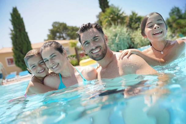 Portrait of happy family at the swimming-pool in summer  - Foto, imagen