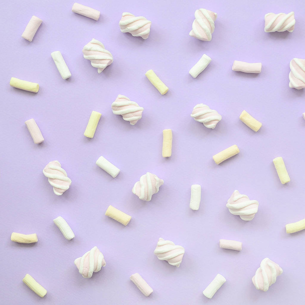Marshmallow colorido colocado no fundo de papel violeta. textura criativa pastel. mínimo
. - Foto, Imagem